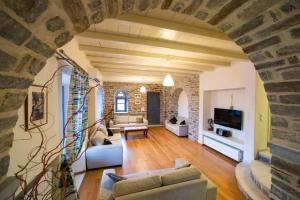 a large living room with a stone wall at Paros Tranquility Villa in Dhragoulás