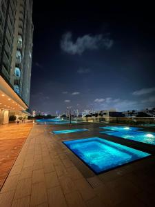 uma piscina com água azul à noite em Paragon Residence 8-12pax-Big Balcony with BBQ em Johor Bahru