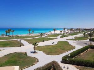 a view of a park with the ocean in the background at Chalet at lazourde bay in El Alamein