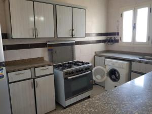 a kitchen with a stove and a washing machine at Chalet at lazourde bay in El Alamein