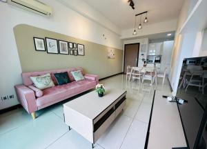 a living room with a pink couch and a table at Paragon Residence 8-12pax-Big Balcony with BBQ in Johor Bahru