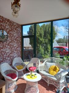 un patio con sillas de mimbre, una mesa y una ventana en Familienfreundliche Ferienwohnung Erzgebirge en Schneeberg