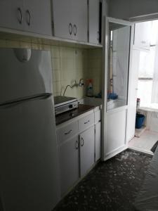 阿利坎特的住宿－Verano，厨房配有白色橱柜和冰箱。