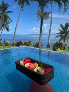 a pool with a tray of fruit in a basket at Lomani in Matei