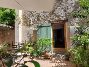 a stone house with a green door and some plants at 17th Century town house in Forcalquier centre in Forcalquier
