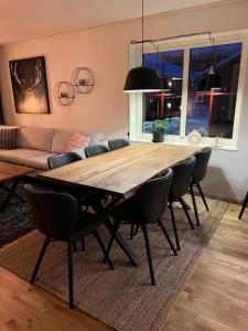 Storhogna Torg في فيمدالين: غرفة طعام مع طاولة وكراسي خشبية