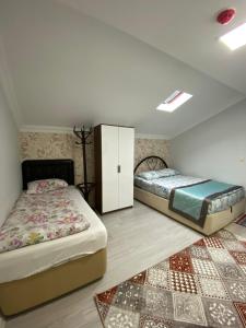 ウズンギョルにあるUzungöl Özkan Pansiyonのベッドルーム1室(ツインベッド2台、ラグ付)