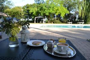 einen Tisch mit einem Frühstück mit Kaffee und einer Tasse Kaffee in der Unterkunft La Locanda nel Frutteto in Rovereto