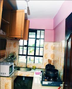 a kitchen with a sink and a stove and a window at Jiji Homes 1 Bedroom house with Wi-Fi king size bed. Free parking in Naivasha