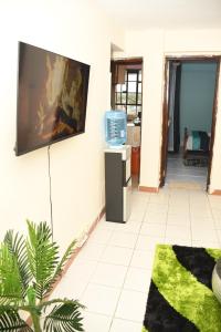 a living room with a tv on the wall at Jiji Homes 1 Bedroom house with Wi-Fi king size bed. Free parking in Naivasha