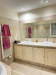 a bathroom with two sinks and a large mirror at Villa Madysan à St Aygulf, plage et mer à 900m, piscine chauffée, jardin privé in Saint-Aygulf