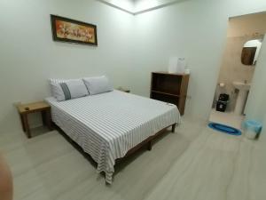 um quarto com uma cama num quarto branco em Sol's Inn - Port Barton em San Vicente