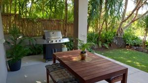 a patio with a table and a grill in a yard at Casa Mia Retreat Luxury Family Home on Buderim in Buderim