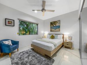 um quarto com uma cama e uma cadeira azul em Casa Mia Retreat Luxury Family Home on Buderim em Buderim