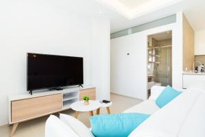 Il comprend un salon doté d'un canapé blanc et d'une télévision à écran plat. dans l'établissement Apartamento Natural Luxury Park, à Ciudad Quesada
