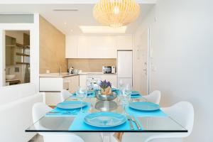 une salle à manger avec une table en verre et des armoires blanches dans l'établissement Apartamento Natural Luxury Park, à Ciudad Quesada