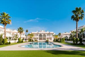 une villa avec une piscine et des palmiers dans l'établissement Apartamento Natural Luxury Park, à Ciudad Quesada