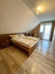 - une chambre avec un lit et du parquet dans l'établissement Betti, à Balatonkeresztúr