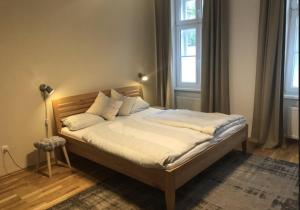 een bed met witte lakens en kussens in een slaapkamer bij Große 4 Zimmer Wohnung. Schönbrunn-Nähe! in Wenen