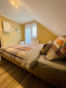 - un grand lit dans une chambre aux murs jaunes dans l'établissement Betti, à Balatonkeresztúr