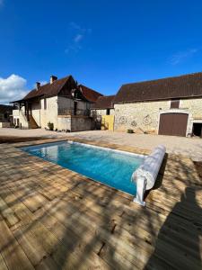 a swimming pool with a bench next to a house at Maison de campagne chez Mamie 4 étoiles in Sainte-Eulalie-dʼAns