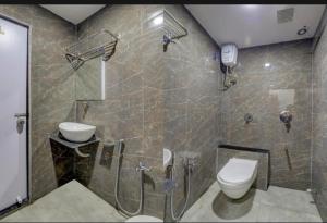 a bathroom with a shower and a toilet and a phone at HOTEL SAROVAR INN in Ahmedabad