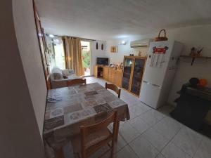 eine Küche mit einem Tisch und einem weißen Kühlschrank in der Unterkunft Casa Antonella in Dolianova