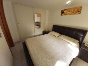 Schlafzimmer mit einem großen Bett mit einem Kopfteil aus Leder in der Unterkunft Casa Antonella in Dolianova