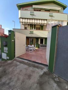 - un bâtiment avec des portes vertes et blanches et une terrasse dans l'établissement Casa Antonella, à Dolianova