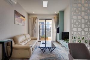 een woonkamer met een bank en een tv bij Saigonroyal Residence - Smile Home -luxury Infinity pool in Ho Chi Minh-stad