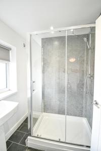 a shower with a glass door in a bathroom at Dalkeith House By Horizon Stays in Hartlepool