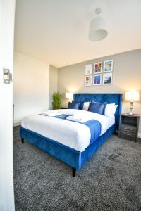 a bedroom with a blue bed with a blue headboard at Dalkeith House By Horizon Stays in Hartlepool