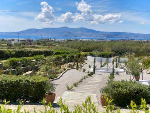 a garden with a pathway and plants and mountains in the background at Plaka Villa 2 Naxos in Plaka
