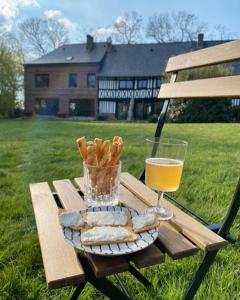 a picnic table with bread and a glass of orange juice at Le Manoir de la Campagne in Yébleron