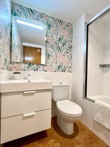 bagno con servizi igienici, lavandino e specchio di Elena Playa Sol a Alcudia