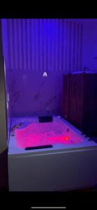 uma banheira com luzes vermelhas num quarto em LE BALI SPA em Hardricourt