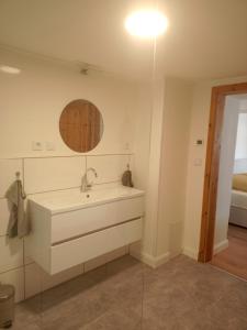 a white bathroom with a sink and a mirror at Stübchen in Nonnweiler