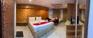 a hotel room with a bed and a desk with a television at The ESSE Hotel Pattaya in Pattaya South