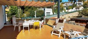 a patio with a table and chairs and an umbrella at Agradable casa con terraza en S'Agaró in Sant Feliu de Guixols