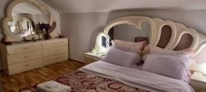 a bedroom with a white bed with a large headboard at Casa Irina in Piatra Neamţ