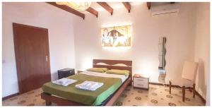 a bedroom with two beds and a painting on the wall at Villa il Glicine in Vulcano