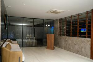 una camera con pareti in vetro, divano e TV di Hotel Tulips Grand a Hyderabad