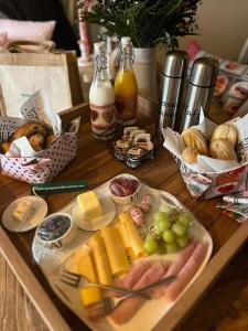 a table with a tray of cheese and grapes and bread at RL Guesthouses in Geilenkirchen