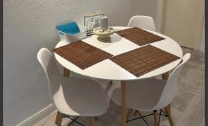 a dining room table with white chairs and a brown and white table at Linas Wohlfühloase Hameln in Hessisch Oldendorf
