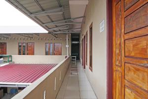 un couloir vide d'une école avec une porte en bois dans l'établissement SPOT ON 92498 Fanni Homestay, à Pekanbaru