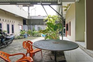 a patio with a table and chairs in a courtyard at SPOT ON 92498 Fanni Homestay in Pekanbaru