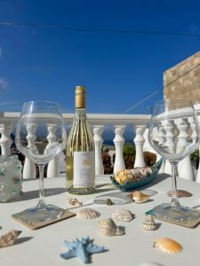 a bottle of wine and two glasses on a table at New Lindos Studio 45 renovated in Líndos