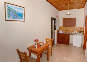una cucina e una sala da pranzo con tavolo e sedie di Romantic Studios a Lithakia