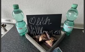 two bottles of water sitting next to a box of chocolates at Sophia Hameln - maritim wohnen im Weserbergland in Hessisch Oldendorf