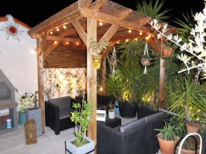 a wooden pergola with potted plants and lights at SETE BELLE MAISON DE VILLE 121 m2 A 2 mn DE LA PLAGE et SPA in Sète